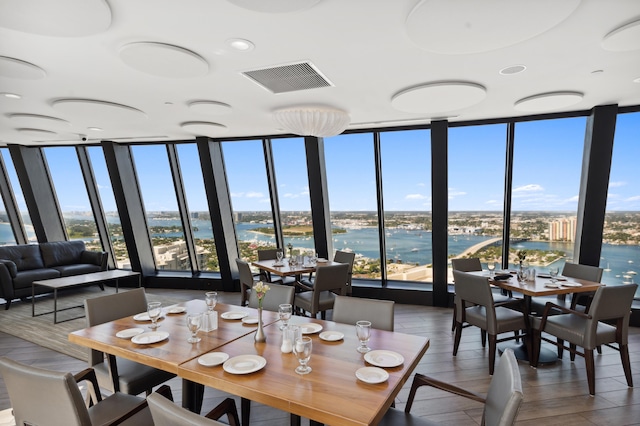 dining area with a water view and a wall of windows