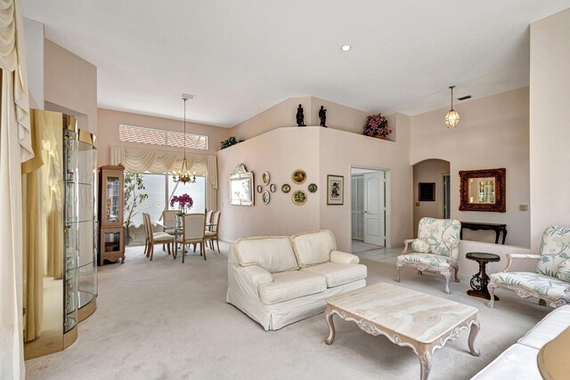 carpeted living room featuring an inviting chandelier