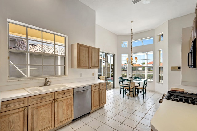 kitchen with sink, an inviting chandelier, stainless steel dishwasher, a towering ceiling, and light tile patterned floors