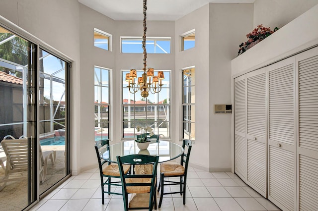 tiled dining space featuring a high ceiling and a chandelier