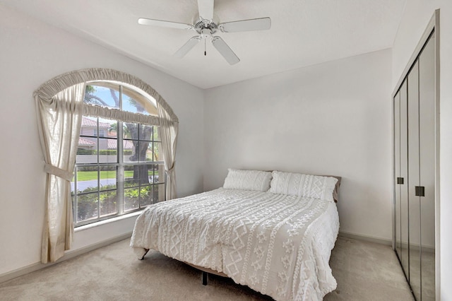 carpeted bedroom with multiple windows, a closet, and ceiling fan