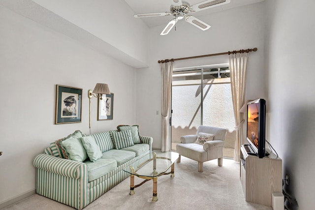 carpeted living room with ceiling fan and a high ceiling