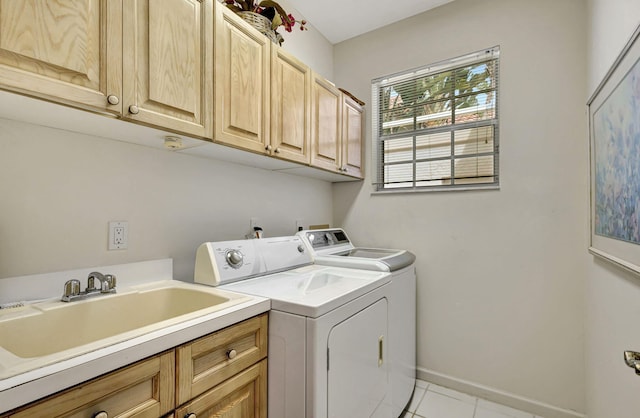 laundry room featuring sink, washer and dryer, cabinets, and light tile patterned flooring