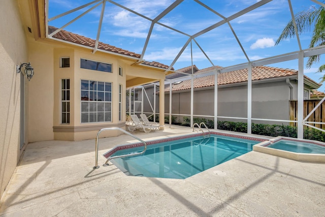 view of pool featuring an in ground hot tub, glass enclosure, and a patio area