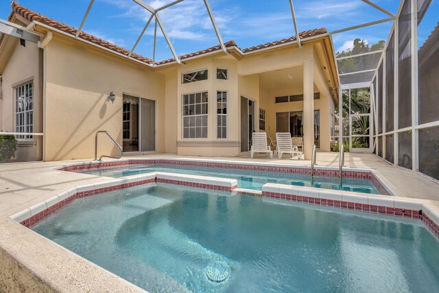 view of swimming pool featuring glass enclosure and a patio