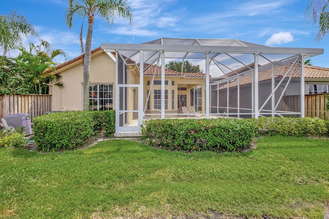 back of house featuring a yard, a patio, and a lanai