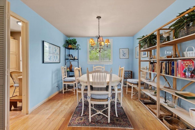 dining space featuring light hardwood / wood-style flooring and a chandelier