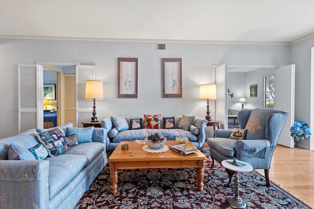 living room with hardwood / wood-style flooring and ornamental molding