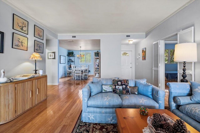 living room with crown molding and light hardwood / wood-style floors