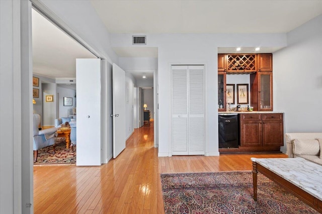 interior space featuring black dishwasher and light hardwood / wood-style floors