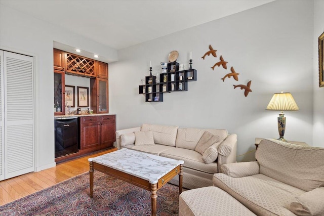 living room with bar area and hardwood / wood-style floors