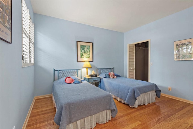 bedroom with a closet, light hardwood / wood-style floors, and a walk in closet