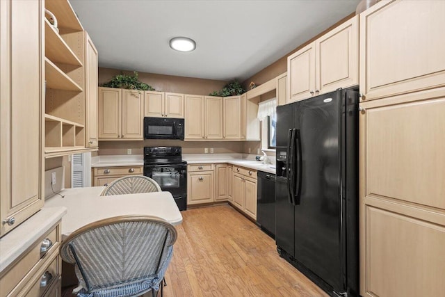 kitchen with black appliances and light hardwood / wood-style floors