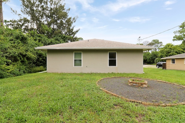 view of home's exterior with a fire pit and a yard