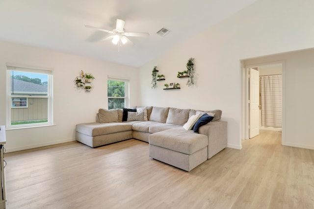 living room with ceiling fan, vaulted ceiling, a wealth of natural light, and light hardwood / wood-style floors