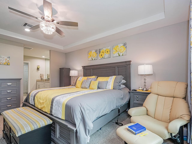 carpeted bedroom featuring ceiling fan and a raised ceiling