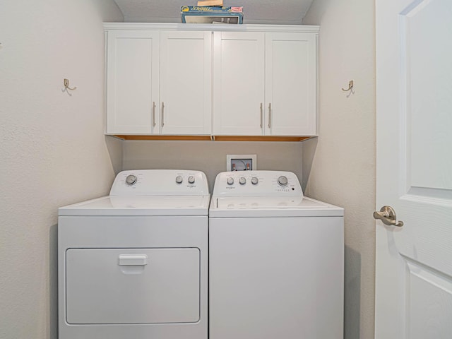 clothes washing area featuring cabinets and separate washer and dryer