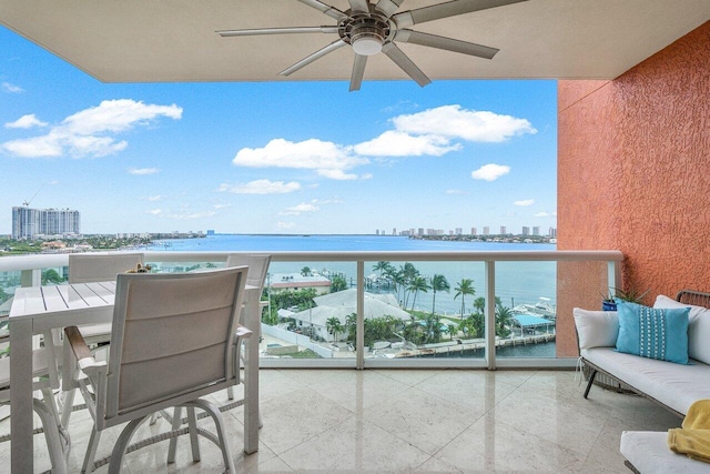 balcony with ceiling fan and a water view