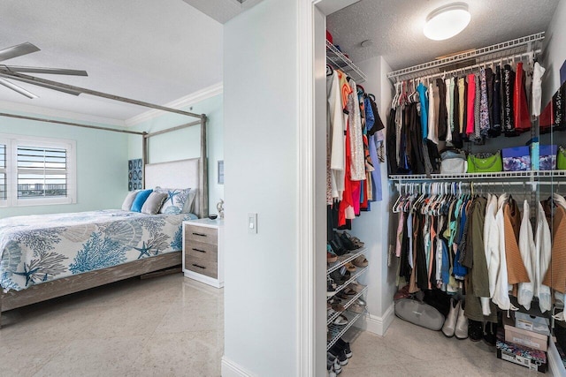 bedroom featuring a textured ceiling, ceiling fan, crown molding, light tile patterned floors, and a closet