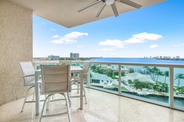 balcony featuring a water view and ceiling fan