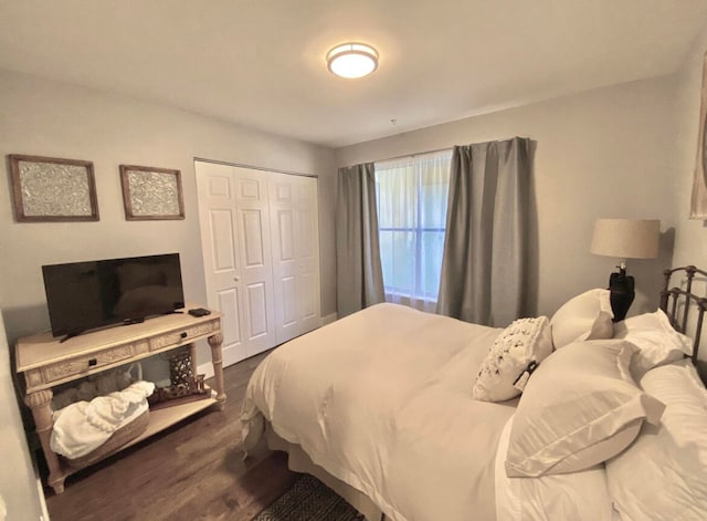 bedroom with dark hardwood / wood-style floors and a closet