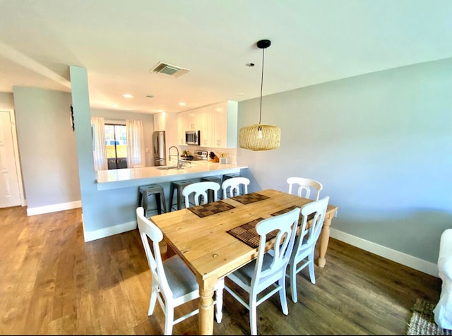 dining area featuring wood-type flooring and sink