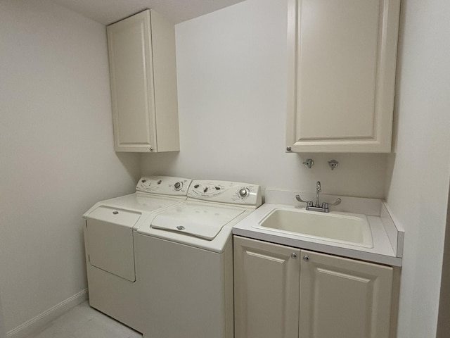 laundry area with washer and clothes dryer, a sink, cabinet space, and baseboards