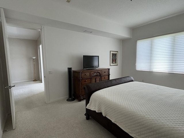 bedroom featuring baseboards, a textured ceiling, and light colored carpet