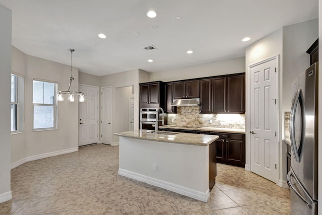 kitchen with stainless steel appliances, an island with sink, hanging light fixtures, and dark brown cabinetry