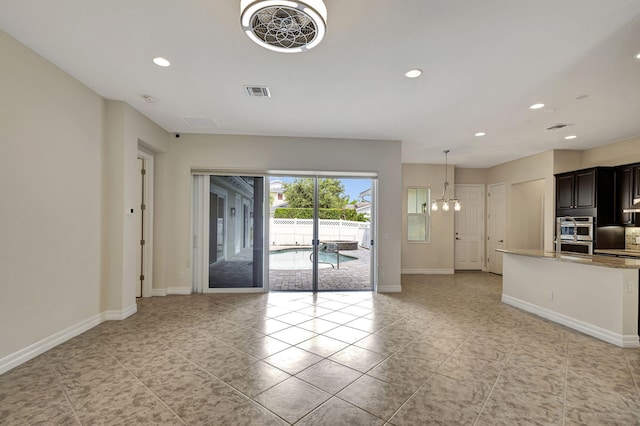 2710 W Mallory Blvd, Jupiter, FL 33458 - unfurnished living room with recessed lighting, baseboards, light tile patterned floors, and a chandelier