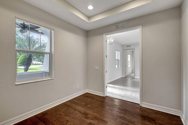 empty room featuring hardwood / wood-style floors and a tray ceiling