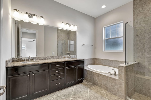 full bath featuring a bath, a stall shower, a sink, and tile patterned floors