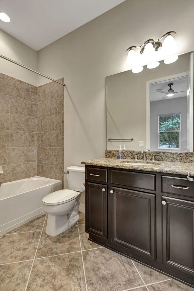 bathroom with shower / washtub combination, toilet, ceiling fan, vanity, and tile patterned flooring