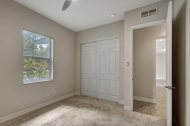 unfurnished bedroom with a closet, visible vents, baseboards, and carpet flooring