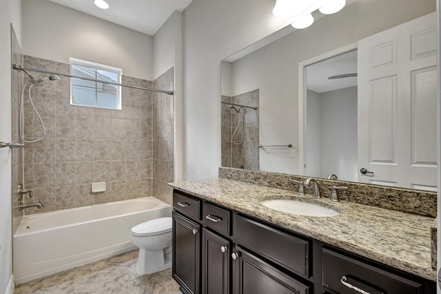 full bathroom with tiled shower / bath, vanity, and toilet