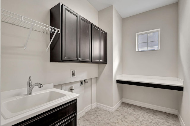 washroom with cabinet space, baseboards, a sink, washer hookup, and electric dryer hookup