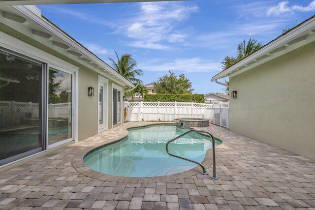 view of swimming pool featuring an in ground hot tub and a patio area