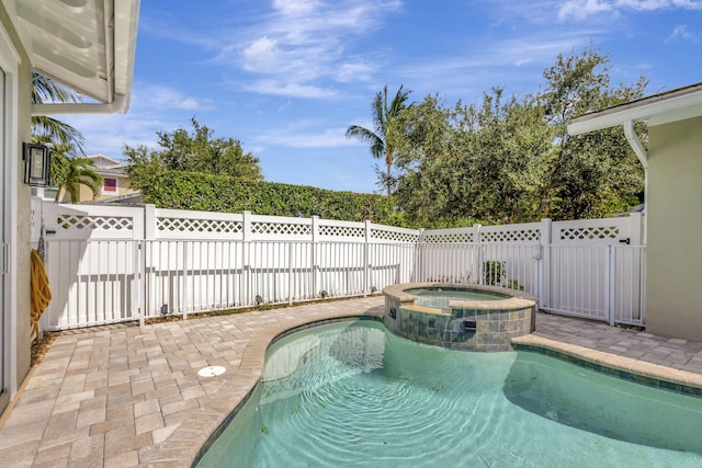 view of swimming pool featuring an in ground hot tub and a patio