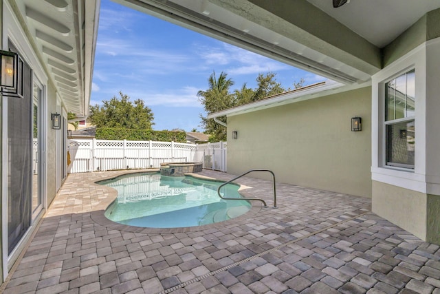 view of pool with a pool with connected hot tub, a fenced backyard, and a patio