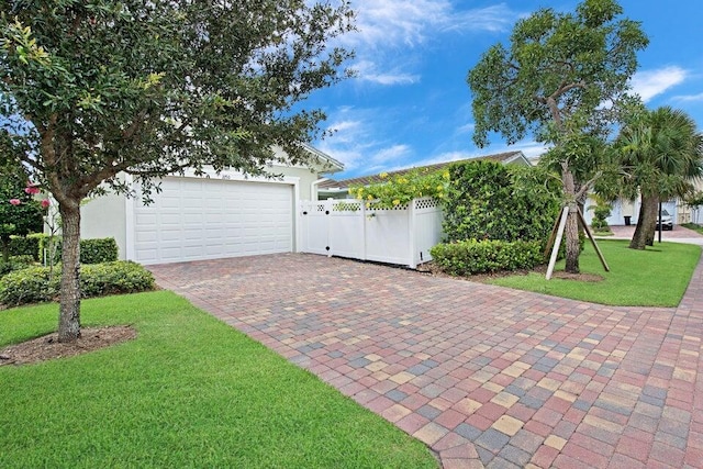 garage with decorative driveway and fence