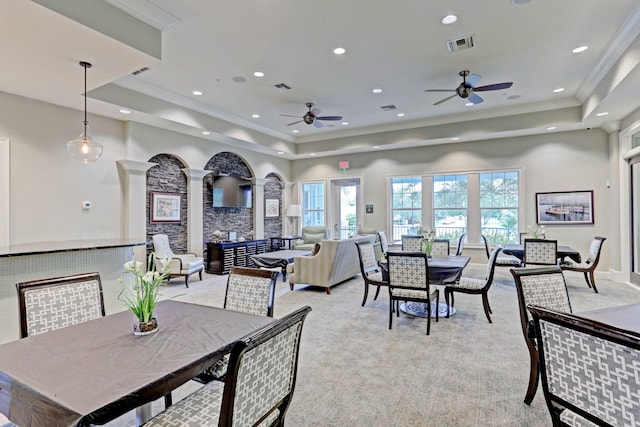 dining space featuring a tray ceiling, light colored carpet, visible vents, and crown molding