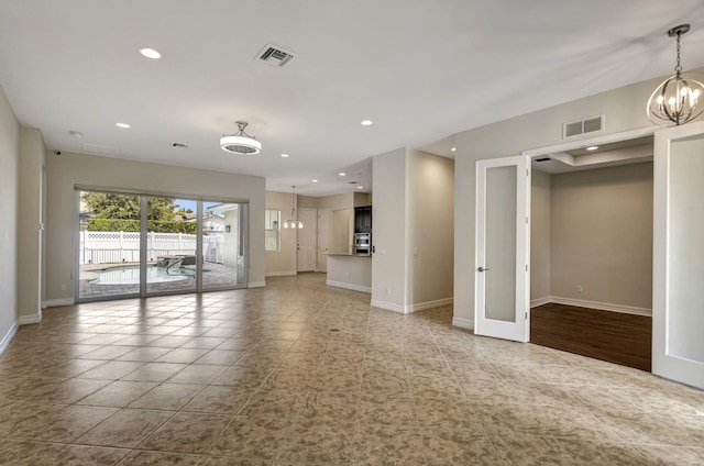 unfurnished living room featuring an inviting chandelier and light tile patterned flooring