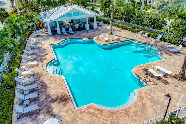 pool featuring an outbuilding, fence, outdoor dry bar, and a patio