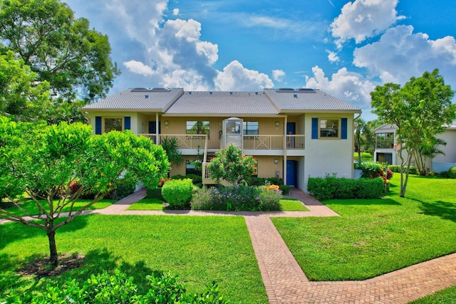 rear view of property with a lawn and a balcony