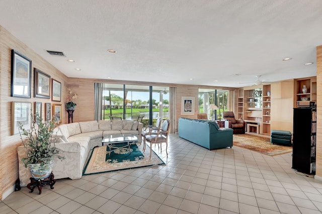 tiled living room featuring ceiling fan and a textured ceiling