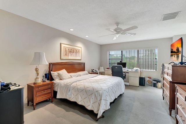 carpeted bedroom with ceiling fan and a textured ceiling