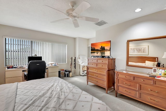 carpeted bedroom featuring ceiling fan and a textured ceiling