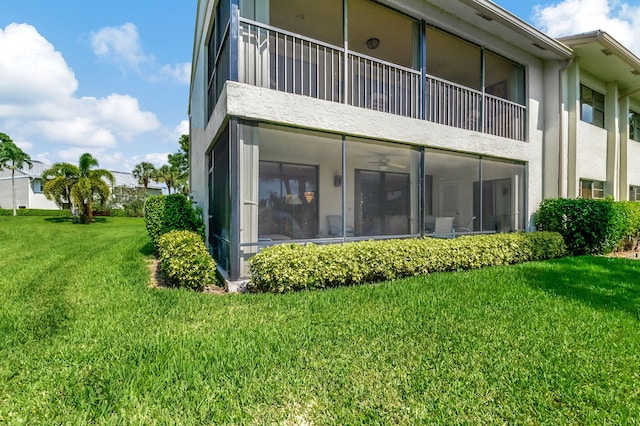 back of property with a sunroom and a yard