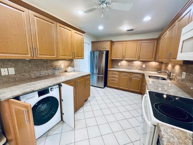 kitchen featuring white appliances, sink, ceiling fan, and tasteful backsplash