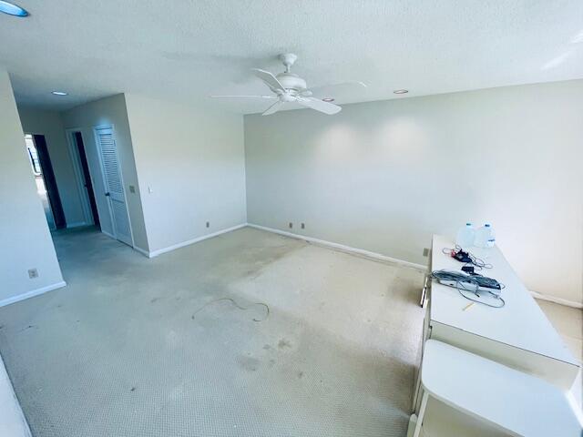 empty room with ceiling fan and carpet flooring